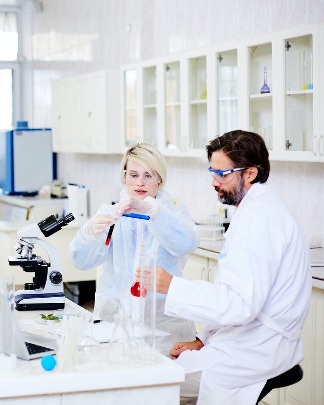 Technicians testing material samples at a laboratory bench